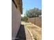 Sideyard view, gravel and weeds with block wall, brick border, and grass beyond at 15023 W Redfield Rd, Surprise, AZ 85379