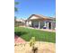 A view of the grassy backyard with patio, shed, and seating area at 15023 W Redfield Rd, Surprise, AZ 85379