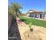 View of the backyard, including grassy area, fence, shed, and trees at 15023 W Redfield Rd, Surprise, AZ 85379