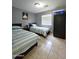 Bedroom featuring tile floors, two twin beds, and a black wardrobe at 15023 W Redfield Rd, Surprise, AZ 85379