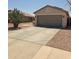 Charming single-story home featuring a two-car garage and desert landscaping at 15023 W Redfield Rd, Surprise, AZ 85379