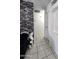 Hallway with neutral colors, featuring tile flooring, a decorative brick wall and white trim at 15023 W Redfield Rd, Surprise, AZ 85379