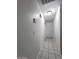 Narrow hallway with tile floors featuring white walls and trim at 15023 W Redfield Rd, Surprise, AZ 85379