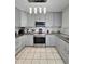 Bright kitchen with stainless steel appliances, granite counters, and gray cabinetry at 15023 W Redfield Rd, Surprise, AZ 85379