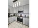 Charming kitchen features stainless steel appliances, granite countertops, and gray cabinetry at 15023 W Redfield Rd, Surprise, AZ 85379