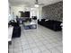 Open-concept living room featuring tile flooring, statement wall, and modern furnishings at 15023 W Redfield Rd, Surprise, AZ 85379