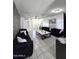 Large living room with tile floors, modern furnishings, and eye-catching accent wall at 15023 W Redfield Rd, Surprise, AZ 85379