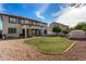Wide backyard with green lawn, stone landscaping, covered patio, grill, and space for outdoor entertaining at 15028 W Minnezona Ave, Goodyear, AZ 85395