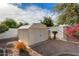 Functional backyard storage shed surrounded by low-maintenance desert landscaping and white brick perimeter fence at 15028 W Minnezona Ave, Goodyear, AZ 85395