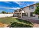 Spacious backyard with lush grass, desert landscaping, and a covered patio area at 15028 W Minnezona Ave, Goodyear, AZ 85395