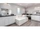 Bright bathroom featuring a soaking tub, dual sinks, and a decorative mirror at 15028 W Minnezona Ave, Goodyear, AZ 85395