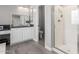 This bathroom features a shower with glass door, light gray tile floors, and a decorative mirror at 15028 W Minnezona Ave, Goodyear, AZ 85395