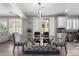 Bright dining area with glass table, stylish chairs, modern light fixture, and view to the backyard at 15028 W Minnezona Ave, Goodyear, AZ 85395