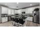 Spacious kitchen boasts white cabinetry, granite countertops, a large island, and stainless steel appliances at 15028 W Minnezona Ave, Goodyear, AZ 85395