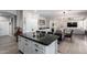 Open concept kitchen flows into the dining area, featuring an island with granite countertops and white cabinets at 15028 W Minnezona Ave, Goodyear, AZ 85395