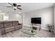 Living room featuring neutral walls, a ceiling fan, wood flooring, and a comfortable sofa at 15028 W Minnezona Ave, Goodyear, AZ 85395