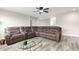Living room showcasing neutral walls, wood flooring, a comfortable sofa, and a glass coffee table at 15028 W Minnezona Ave, Goodyear, AZ 85395