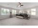 Spacious primary bedroom with plush carpeting, a ceiling fan, and large windows offering natural light at 15028 W Minnezona Ave, Goodyear, AZ 85395