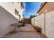 Spacious side yard with a table, brick perimeter fence, and concrete surface at 15028 W Minnezona Ave, Goodyear, AZ 85395
