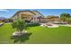 Backyard oasis with a pool, fire pit, palapas, and well-manicured turf at 15211 N 184Th Ct, Surprise, AZ 85388