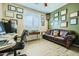 Home office featuring a leather sofa, desk, shuttered windows, and wood-look floors at 15211 N 184Th Ct, Surprise, AZ 85388