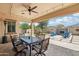 Relaxing covered patio with ceiling fan, stone pillars, cafe lights, and a view of the outdoor living space at 15849 W Alvarado Dr, Goodyear, AZ 85395