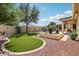 Spacious backyard featuring green synthetic lawn, lush landscaping, and outdoor spaces for relaxing and entertaining at 15849 W Alvarado Dr, Goodyear, AZ 85395