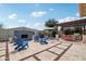 Entertain in style with this backyard featuring a stone fireplace, outdoor kitchen, and ample seating under a pergola at 15849 W Alvarado Dr, Goodyear, AZ 85395