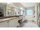 Bright and airy bathroom featuring dual sinks, granite counters, soaking tub, glass shower and private toilet at 15849 W Alvarado Dr, Goodyear, AZ 85395