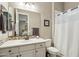 Well-lit bathroom with a white vanity, tiled backsplash, and shower with a curtain at 15849 W Alvarado Dr, Goodyear, AZ 85395