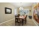A formal dining room with elegant decor, featuring a chandelier and natural light creating a welcoming atmosphere at 15849 W Alvarado Dr, Goodyear, AZ 85395