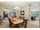An inviting dining room with a wooden table, stylish chandelier, and view into the kitchen and living areas at 15849 W Alvarado Dr, Goodyear, AZ 85395