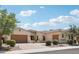 Elegant single-story home with manicured shrubs, a paver driveway, and a three-car garage at 15849 W Alvarado Dr, Goodyear, AZ 85395