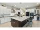 A modern kitchen featuring white cabinets, stainless steel appliances, and a spacious dark wood island with light countertop at 15849 W Alvarado Dr, Goodyear, AZ 85395