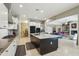 Well-lit kitchen featuring a large island, white cabinets, stainless steel appliances, and an open-concept layout at 15849 W Alvarado Dr, Goodyear, AZ 85395