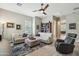 Relaxing living room featuring neutral tones, comfortable seating, a ceiling fan, and a built-in bookcase at 15849 W Alvarado Dr, Goodyear, AZ 85395