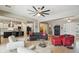 Bright and airy living room with comfortable seating, a ceiling fan, and an open layout leading to the kitchen at 15849 W Alvarado Dr, Goodyear, AZ 85395