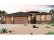A home with a neutral color scheme, stone accents, and a three-car garage is showcased at 17747 W Fulton St, Goodyear, AZ 85338