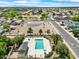 Aerial view features a community pool with surrounding mature trees, desert landscape, and residential street at 17912 N 88Th Dr, Peoria, AZ 85382