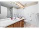 Bright bathroom featuring a large mirror, vanity with white sink, and neutral wall color at 17912 N 88Th Dr, Peoria, AZ 85382