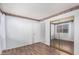 Bedroom featuring wood-look floors, a sliding closet and a door to another room at 17912 N 88Th Dr, Peoria, AZ 85382