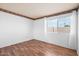 Bedroom with wood-look flooring, a window with blinds and a view of the yard at 17912 N 88Th Dr, Peoria, AZ 85382