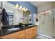 Bathroom with a double vanity, granite countertops, and a glass-enclosed shower at 17958 W Udall Dr, Surprise, AZ 85374