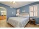 Blue bedroom featuring tile floors, plantation shutters, and an ensuite bathroom at 17958 W Udall Dr, Surprise, AZ 85374