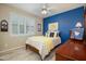 Bedroom with blue accent wall, light tile floors, and large window with shutters at 17958 W Udall Dr, Surprise, AZ 85374