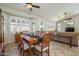 Open dining room with bright natural light, a ceiling fan, and an adjacent living area at 17958 W Udall Dr, Surprise, AZ 85374