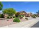 Well-maintained home exterior featuring a tiled roof, desert landscaping, and attached garages at 17958 W Udall Dr, Surprise, AZ 85374