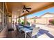 Covered outdoor patio dining area, complete with a ceiling fan and desert landscaping at 17958 W Udall Dr, Surprise, AZ 85374
