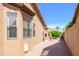 Narrow side yard with desert landscaping, a water feature, and a glimpse of the back patio at 17958 W Udall Dr, Surprise, AZ 85374