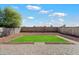 Backyard featuring pavers, gravel, and artificial grass against a block wall, creating a neat outdoor space at 1887 W Desert Seasons Dr, Queen Creek, AZ 85144
